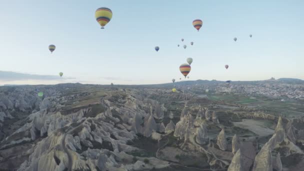 五颜六色的热气球飞越土耳其戈雷梅山谷。来自世界各地的游客来到卡帕多西亚, 乘坐热气球旅行 — 图库视频影像
