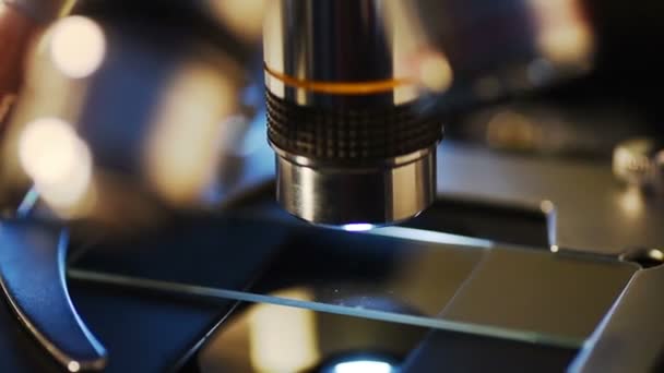 研究所、医療研究の背景、科学的な医療機器試験サンプルの顕微鏡. — ストック動画