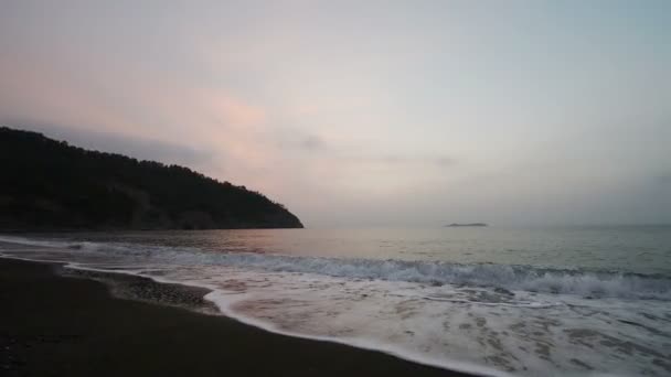 Spokojne fale morza na piaszczystej plaży o zachodzie słońca. Słońca odbicie w wodzie morskiej. Tle natura. Wieczór piękny Hd video — Wideo stockowe