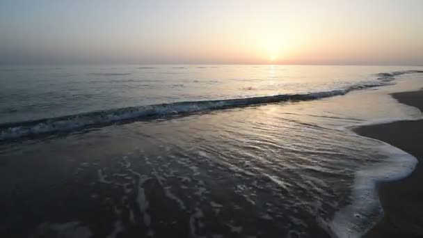 Closeup klid vlny na moři na Sandy pláž při západu slunce. Odraz slunce v mořské vodě. Přírodní pozadí. Večer krásné Hd video — Stock video