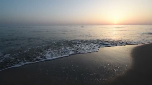 特写镜头平静的海水在日落的沙地海滩上。海水中的太阳反射。自然背景。晚上美丽的高清视频 — 图库视频影像