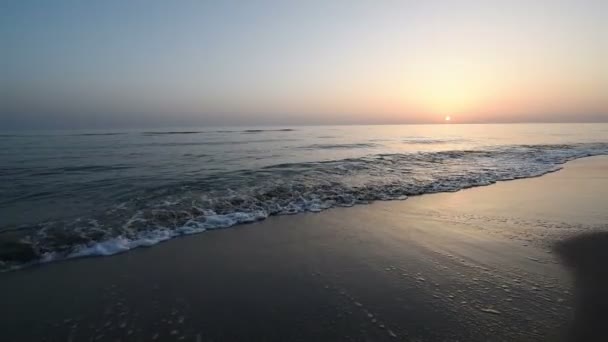 夕暮れ時の砂浜で海の波は穏やかなクローズ アップ。海の水に太陽の反射。自然の背景。美しい Hd ビデオを夜 — ストック動画