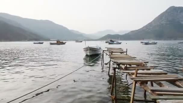 Scenic view of boats at sea bay, old wooden pier in the water, and low mountains on the background. Turkey — Stock Video