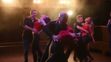 Genç enerjik çekici çiftler akşam vakti açık hava partisinde salsa, bachata, latin dansı yapıyorlar..