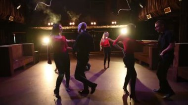 Genç enerjik çekici çiftler akşam vakti açık hava partisinde salsa, bachata, latin dansı yapıyorlar..