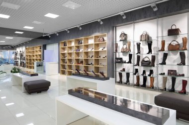 Modern alışveriş merkezindeki ayakkabı mağazasının parlak ve modaya uygun iç mimarisi.