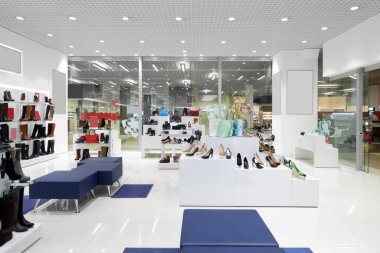 Modern alışveriş merkezindeki ayakkabı mağazasının parlak ve modaya uygun iç mimarisi.