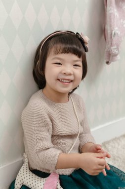 Normal kapalı hayat arka planda duran küçük güzel Asyalı kız.