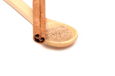 Tarçın baharat üzerinde beyaz izole kaşık ile sopa