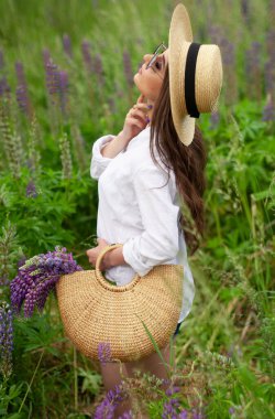Çok çekici bir kız. Çiçeklerin doğasında rahatlar.