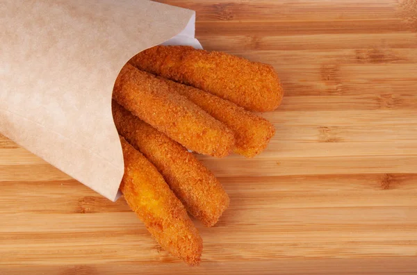 Kızarmış balık kroketleri ahşap arka planda fast food atıştırıyor.