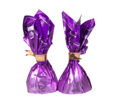 Beyaz folyoyla izole edilmiş menekşe rengi çikolatalı tatlılar.