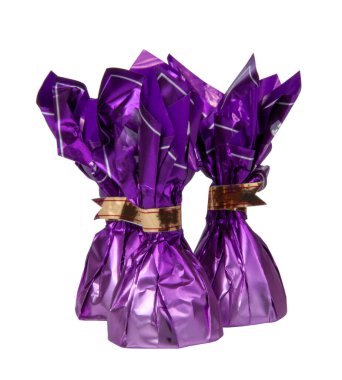 Beyaz folyoyla izole edilmiş menekşe rengi çikolatalı tatlılar.