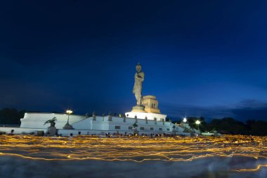 Uzun pozlama fotoğraf. Phutthamonton alan, Nakornprathom, Tayland geceleri Buda heykeli yürüyüş için bir mum tutan birçok Tay kişi.