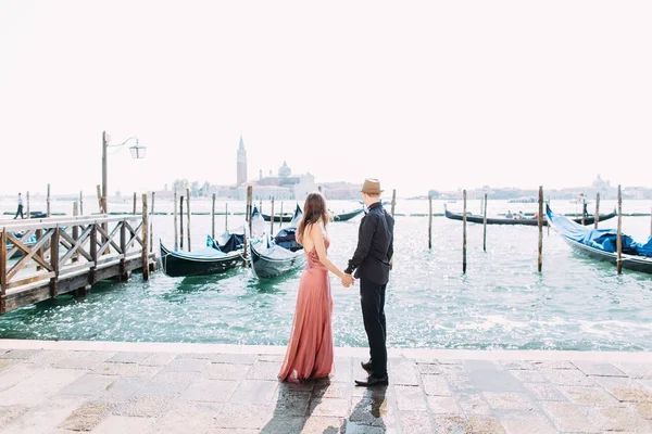 ヴェネツィアでの新婚旅行中に海岸に沿って歩くカップル — ストック写真
