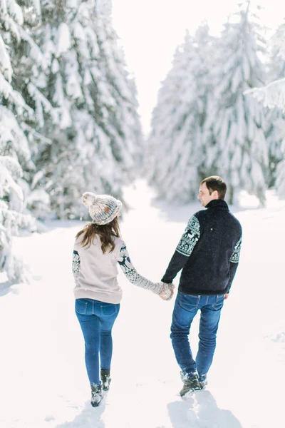 年轻夫妇走在下雪的冬天森林 一起度过圣诞假期 — 图库照片