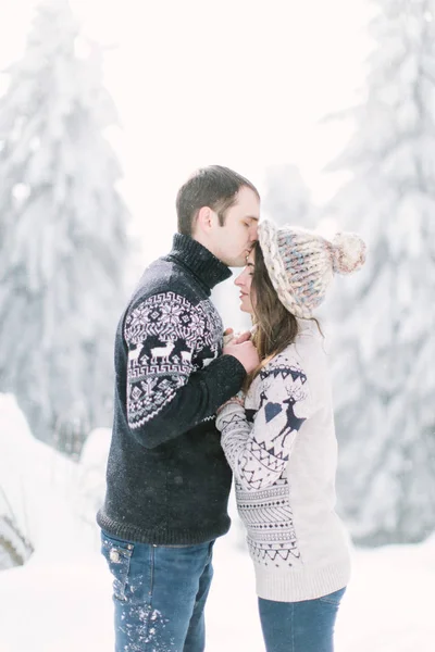 年轻的人亲吻妇女在寒冷的冬天森林 — 图库照片