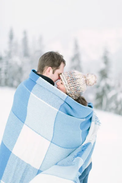节日的概念 森林里的冬天的爱 年轻的夫妇走在雪林 拥抱和微笑 拿着温暖的奶酪毯子 — 图库照片