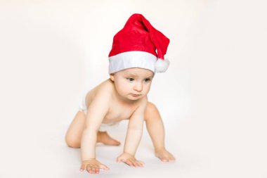 Noel Baba'nın kırmızı şapkalı küçük bebek Noel kutluyor. Kırmızı bere yılında Noel fotoğrafı. Yılbaşı tatil.