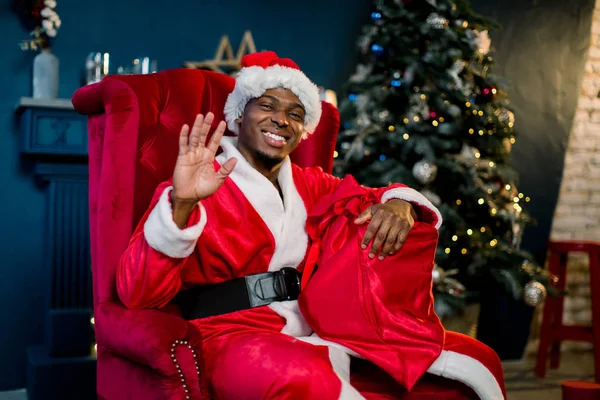 幸せな笑顔肘掛け椅子で休んでいるクリスマス ツリー 暖炉の横にある彼の家でアフリカのサンタ クロース クリスマス休暇 — ストック写真