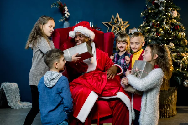 Afrikaanse Kerstman Zit Geeft Presenteert Mooie Kleine Kinderen Een Kerst — Stockfoto