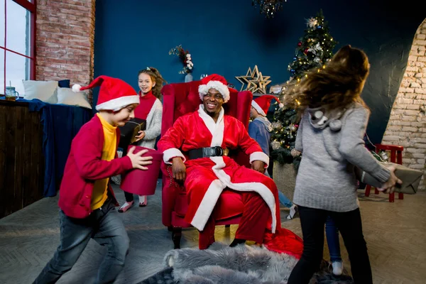 クリスマスの部屋にサンタ クロースのプレゼントで幸せな子供を実行します — ストック写真