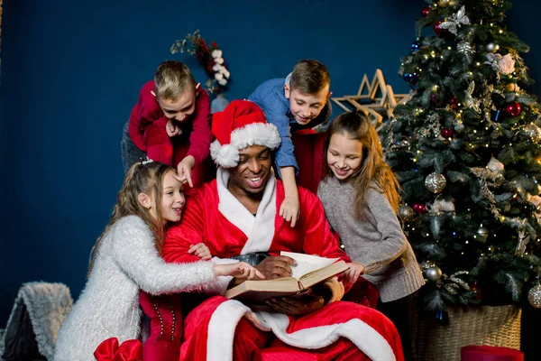 Santa Claus Leest Een Oude Boek Met Kerstmis Verhalen Voor — Stockfoto