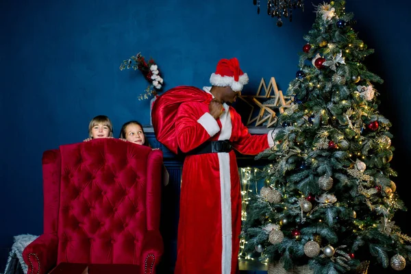 Due Bambine Guardano Fuori Dalla Sedia Rossa Come Babbo Natale — Foto Stock