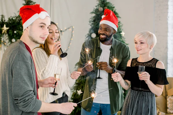 アフリカ少年と白人の少女と少年は笑みを浮かべてシャンパンとベンガルの火災新年やクリスマスを祝う — ストック写真