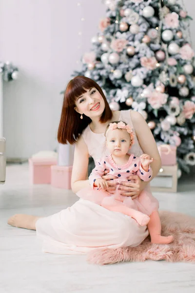 Щасливі Молода Мама Рожевій Сукні Сидячи Підлогу Перед Оформлені Ялинку — стокове фото