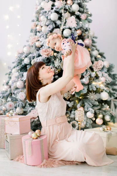 幸せな母と赤ちゃん娘の演奏は クリスマス休暇のホームします 新年の休日 クリスマス ツリーとお祝いに飾られた部屋で母と幼児 母と赤ん坊の娘の肖像 — ストック写真