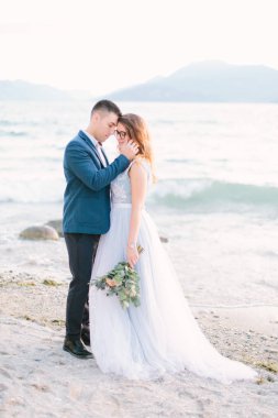 Genç adam düğün töreni gölde yakınındaki iskelede duran güzel kadını sarılma ihale portresi. Garda Gölü, İtalya