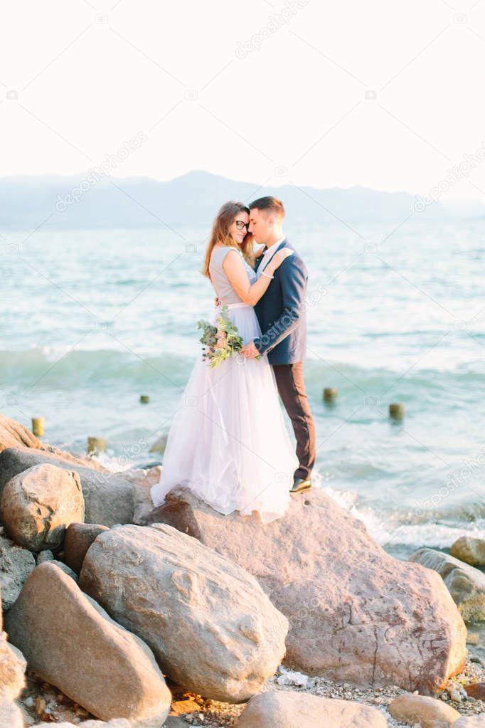 young beautiful couple in blue clothes posing near the Garda lake in Sirmione