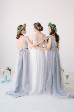 Düğün. Ayakta ve dekor ile beyaz odada nedime kucaklayan beyaz bir elbise içinde gelin