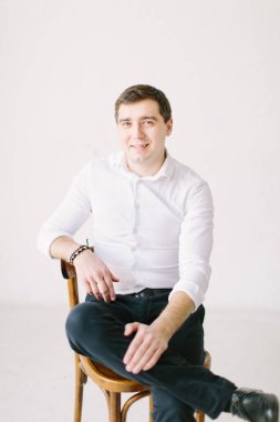 şık yakışıklı damat forması koyarak ve yay, ipe sağdıç sabah hazır almak için ona yardım ederken poz. Düğün hazırlığı. siyah beyaz fotoğraf