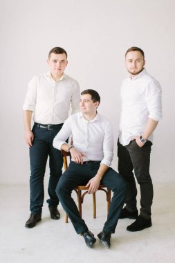 Damat ve sağdıç alışılmadık appearane ile beyaz odada poz