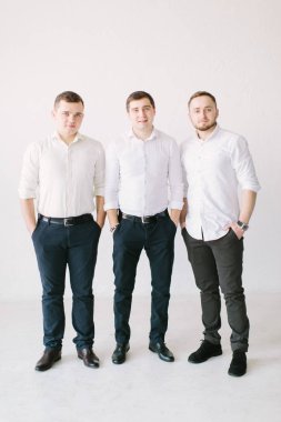 şık yakışıklı damat forması koyarak ve yay, ipe sağdıç sabah hazır almak için ona yardım ederken poz. Düğün hazırlığı. siyah beyaz fotoğraf