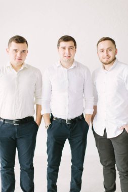 şık yakışıklı damat forması koyarak ve yay, ipe sağdıç sabah hazır almak için ona yardım ederken poz. Düğün hazırlığı. siyah beyaz fotoğraf