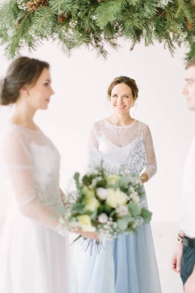 Leading or master of ceremonies, bride and groom at wedding ceremony with decorations and pine arch in rustic style. Master of ceremony speech on microphone background wedding couple.