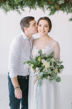 Düğün çift gelin buketi ve damat ile gelin öpüyor. Düğün dekor ışık Studio