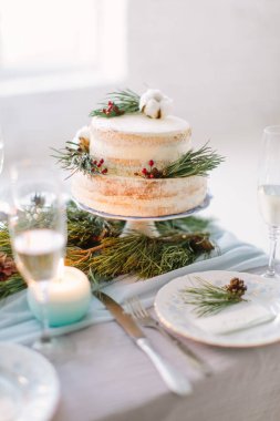 Çam, çilek ve pamuk çiçek dekor, kaplamalar ve mumlar ile düğün tabloda düğün pastası süslenmiş