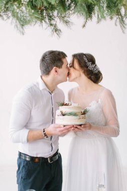 Gelin ve damat restoranın ziyafet salonunda masada öpüşme ve düğün pastası tutan çilek ve pamuk ile dekore edilmiştir. Yeni evliler ve kapalı. Töreni düğün çiçek ve yeşillik ile dekore edilmiş.