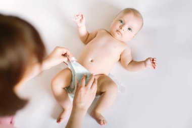 Anne yeni doğan bebeğiyle bez değiştiriyor. Günlük annelik rutini. Aile yaşam tarzı.