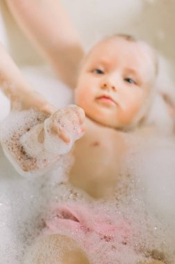 Mutlu küçük bir yüzme banyoda bebeğim. Bir banyoda köpüklü banyo bebek portresi