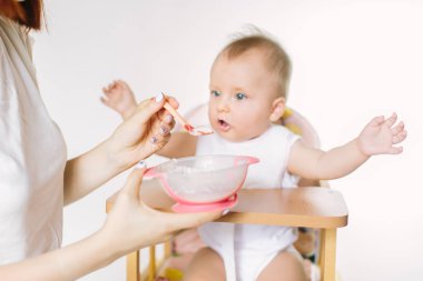 Beslenme çocuk anne. Genç çocuk için ilk katı yiyecek. Çocuklar için sağlıklı beslenme. Ebeveynler çocukları besleme.