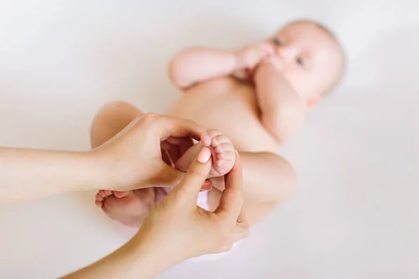 Matka Rukou Masírovat Nohy Svého Dítěte Bílém Pozadí — Stock fotografie