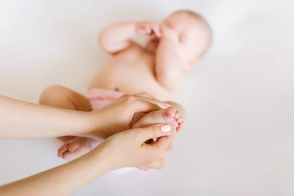 Matka Rukou Masírovat Nohy Svého Dítěte Bílém Pozadí — Stock fotografie