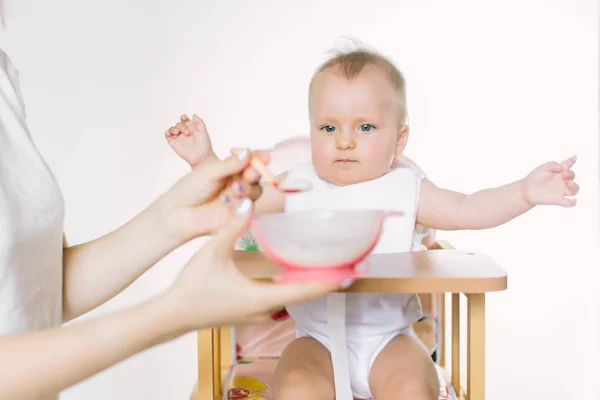 Mãe Alimenta Bebê Uma Cadeira Bebê Com Uma Colher — Fotografia de Stock