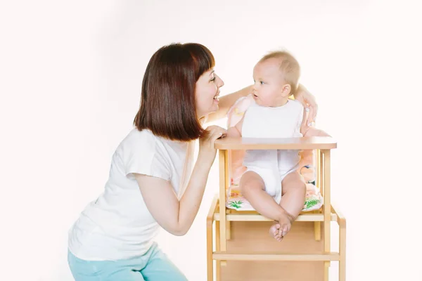 Giovane Bella Madre Mette Bavaglino Bianco Sulla Sua Bambina Seduta — Foto Stock