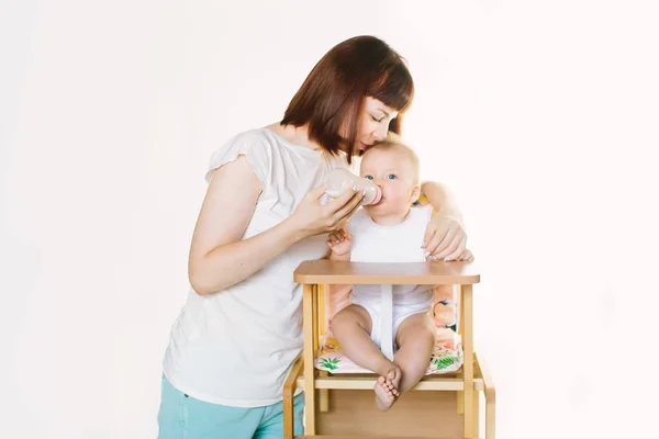Una Bella Giovane Madre Bacia Sua Bambina Seduta Una Poltrona — Foto Stock